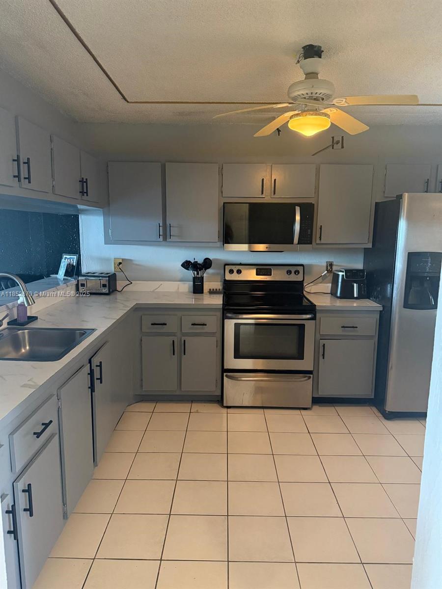 8040 Hampton Boulevard, Unit 512 North Lauderdale, FL 33068 - Photo 6 of 18 a kitchen with a sink a stove and a microwave