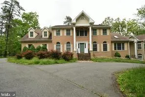 a front view of a house with a yard and trees