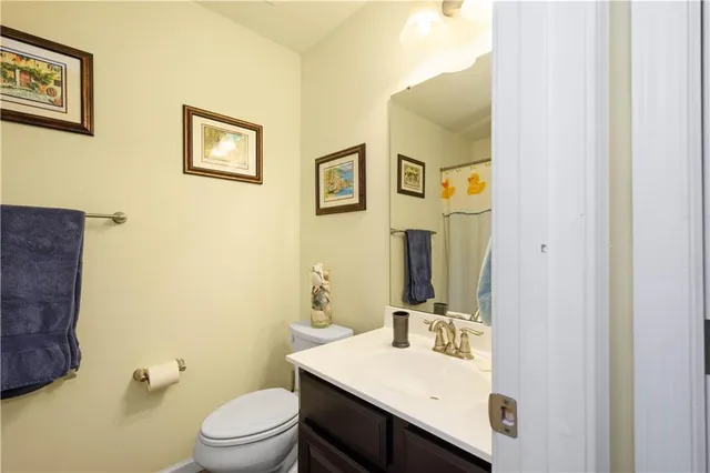 a bathroom with a sink vanity mirror and toilet