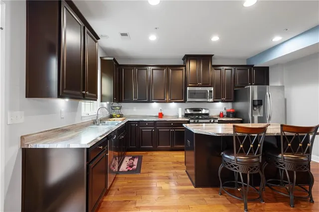 a kitchen with kitchen island granite countertop stainless steel appliances lots of counter top space cabinets and furniture