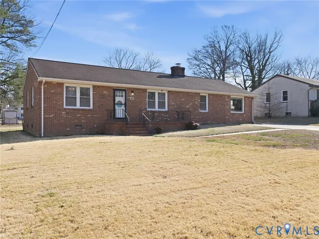 a front view of house with yard and trees around