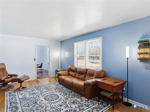 a living room with furniture a rug and a window