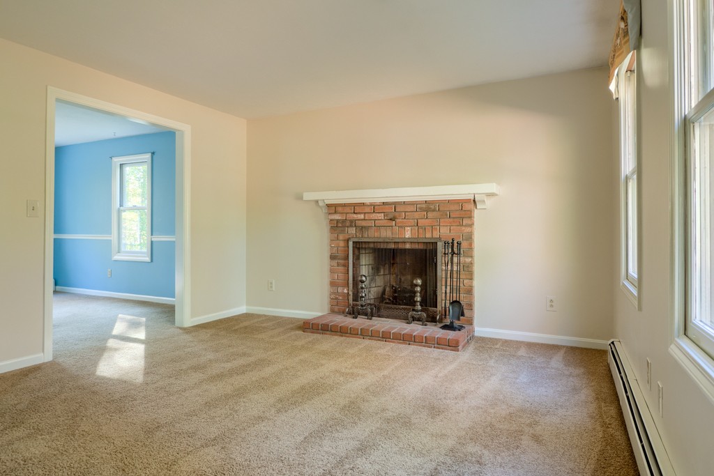 140 Bullard Road Oakham, MA 01068 - Photo 13 of 29 an empty room with a fireplace and window