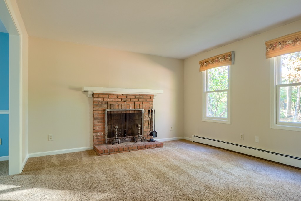 140 Bullard Road Oakham, MA 01068 - Photo 14 of 29 an empty room with fireplace and windows