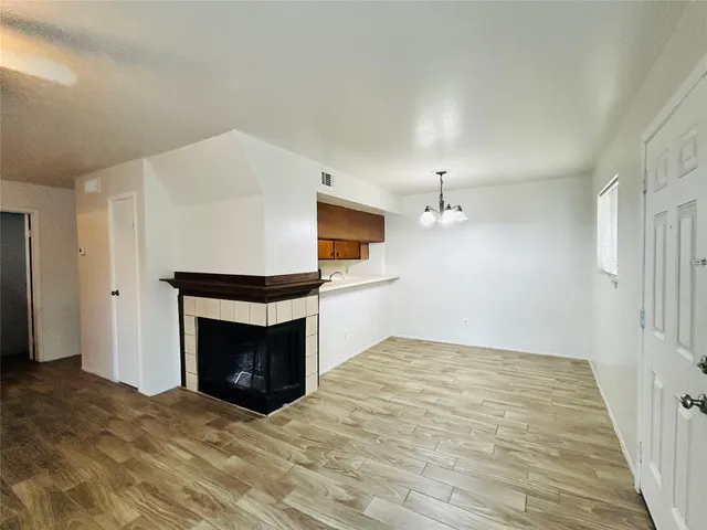 a view of an empty room with a fireplace and a window