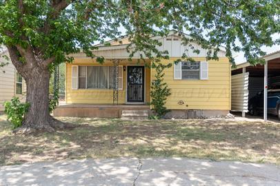 a front view of a house with a tree