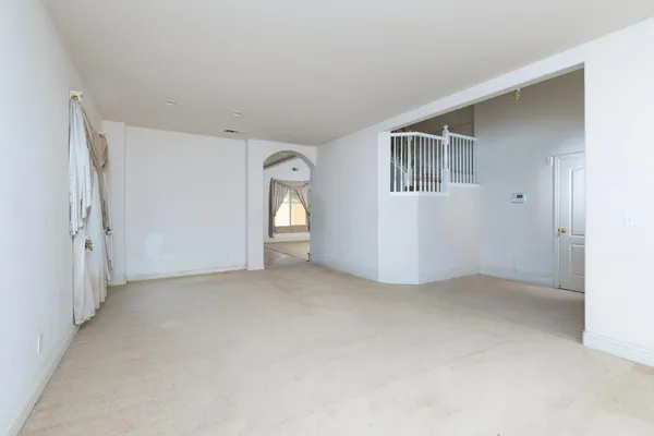 an empty room with a dining space and a window