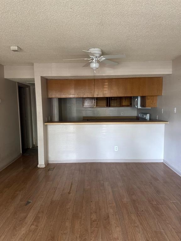 6108 Abrams Road, Unit 103 Dallas, TX 75231 - Photo 2 of 17 a view of a room with wooden floors and a fireplace