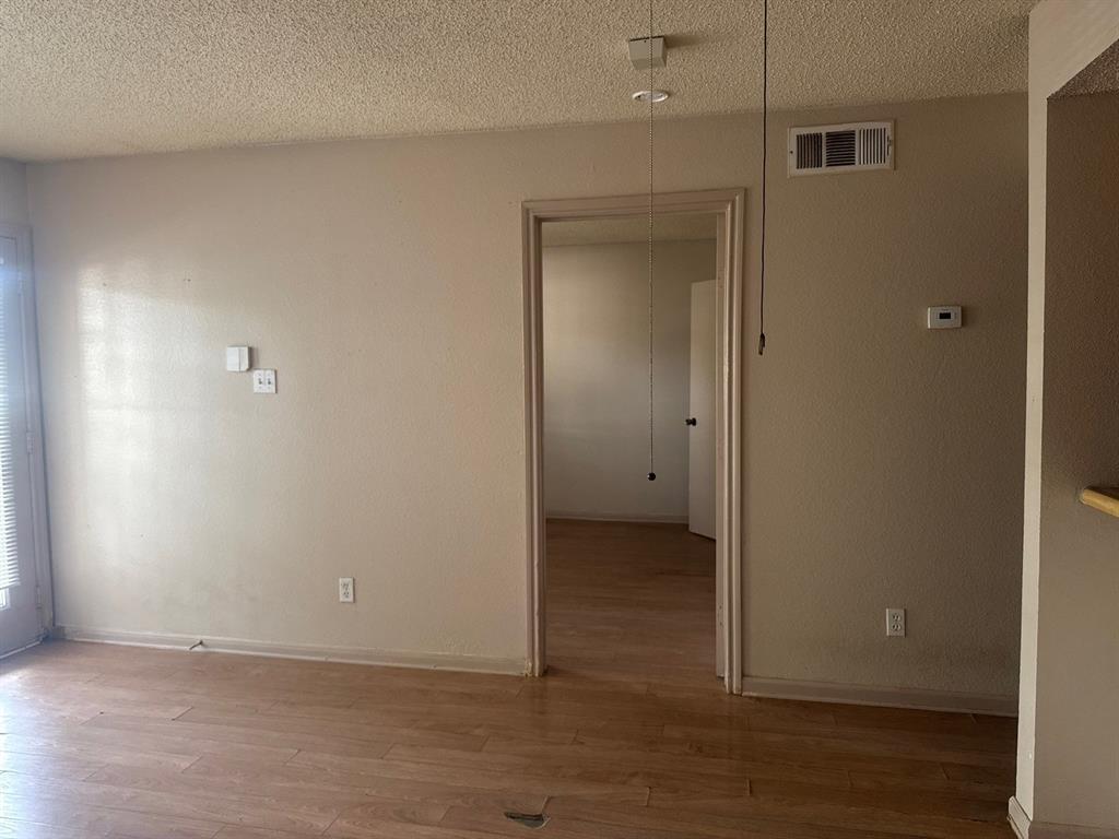 6108 Abrams Road, Unit 103 Dallas, TX 75231 - Photo 4 of 17 an empty room with wooden floor and closet
