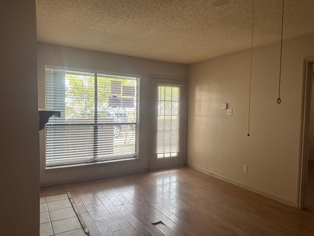 6108 Abrams Road, Unit 103 Dallas, TX 75231 - Photo 5 of 17 a view of an empty room with wooden floor and a window