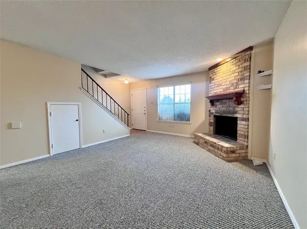 a view of an empty room with a fireplace and a window