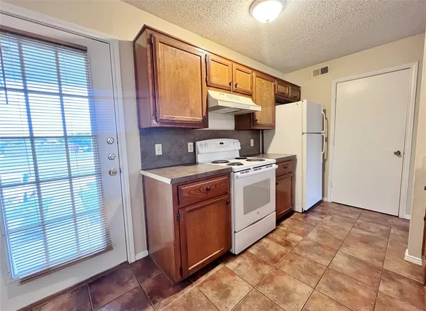 a kitchen with white cabinets and white appliances