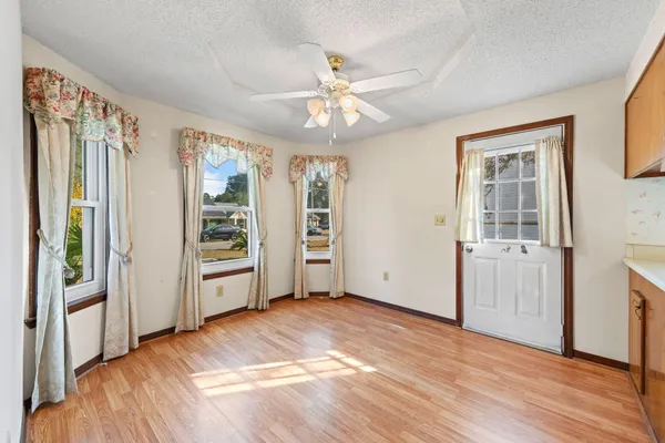a view of kitchen with stainless steel appliances granite countertop a stove and a wooden floors