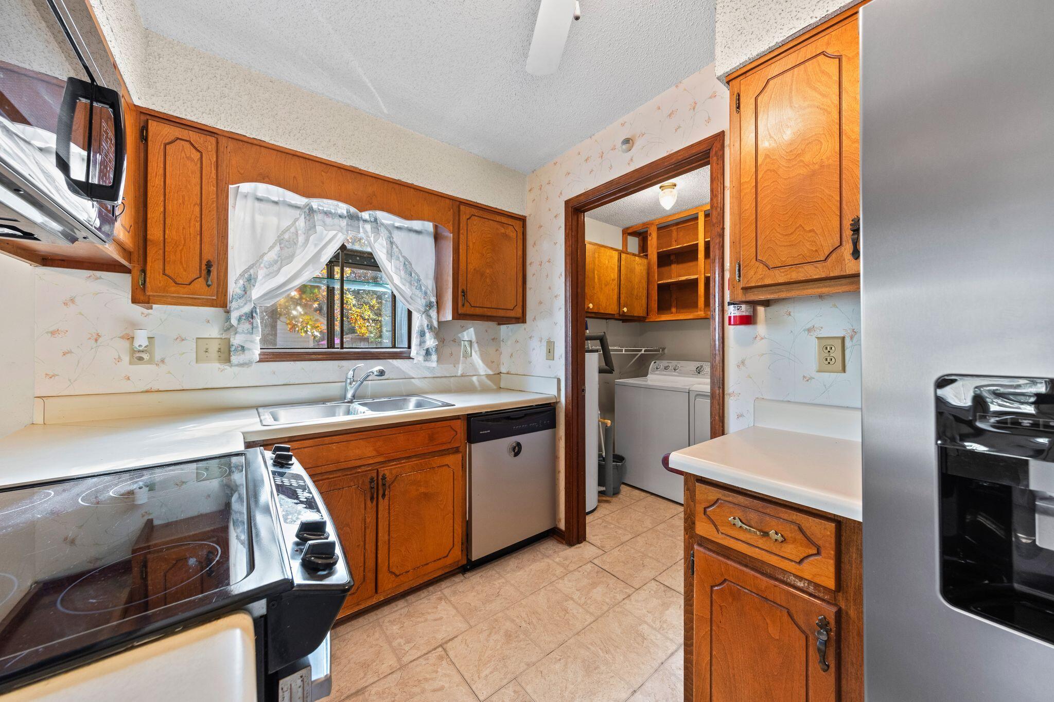 144 Oak Terrace Drive Crestview, FL 32539 - Photo 17 of 61 a kitchen with stainless steel appliances granite countertop a stove a sink and a microwave