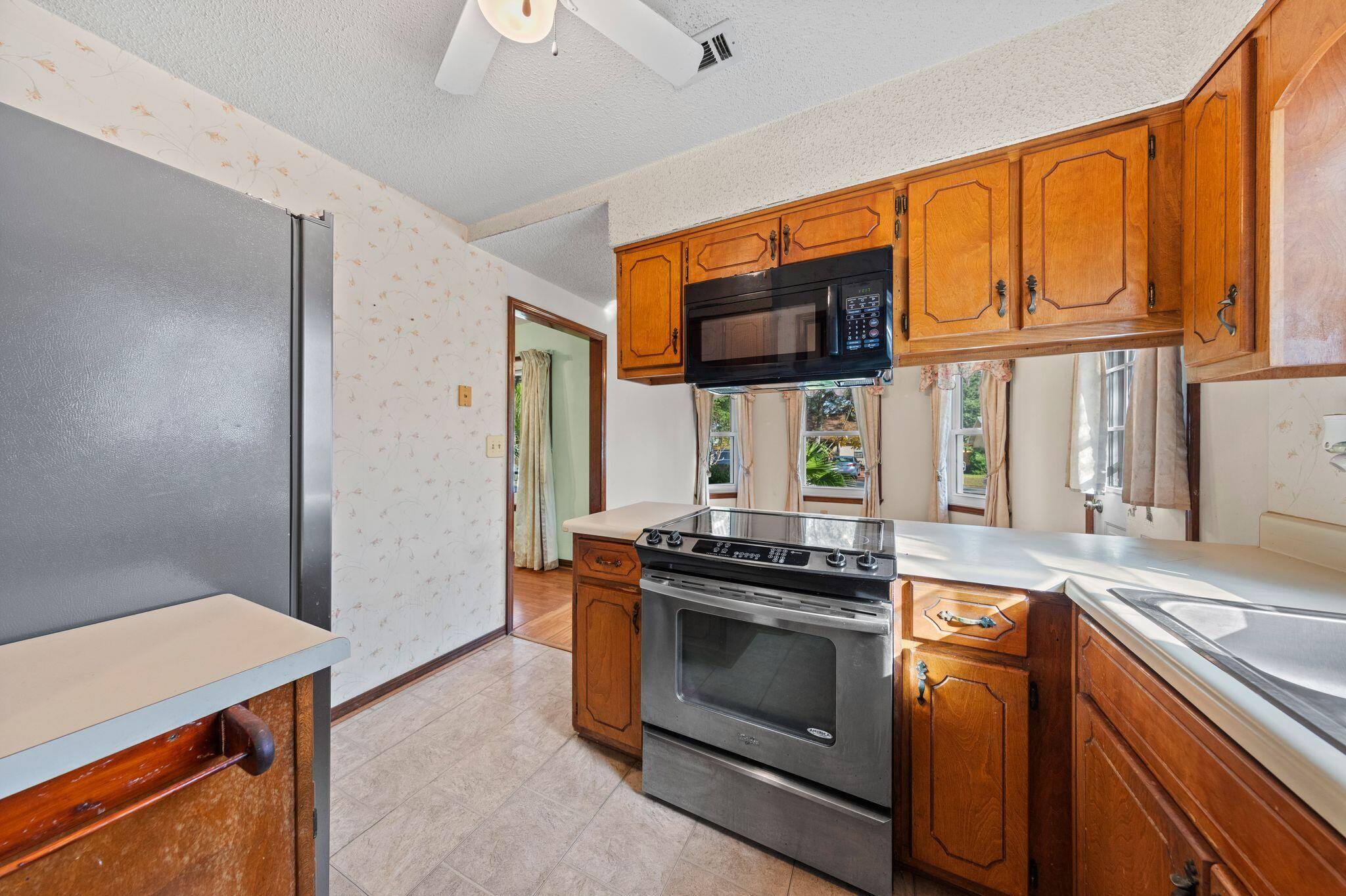 144 Oak Terrace Drive Crestview, FL 32539 - Photo 21 of 61 a kitchen with stainless steel appliances granite countertop a stove and a microwave