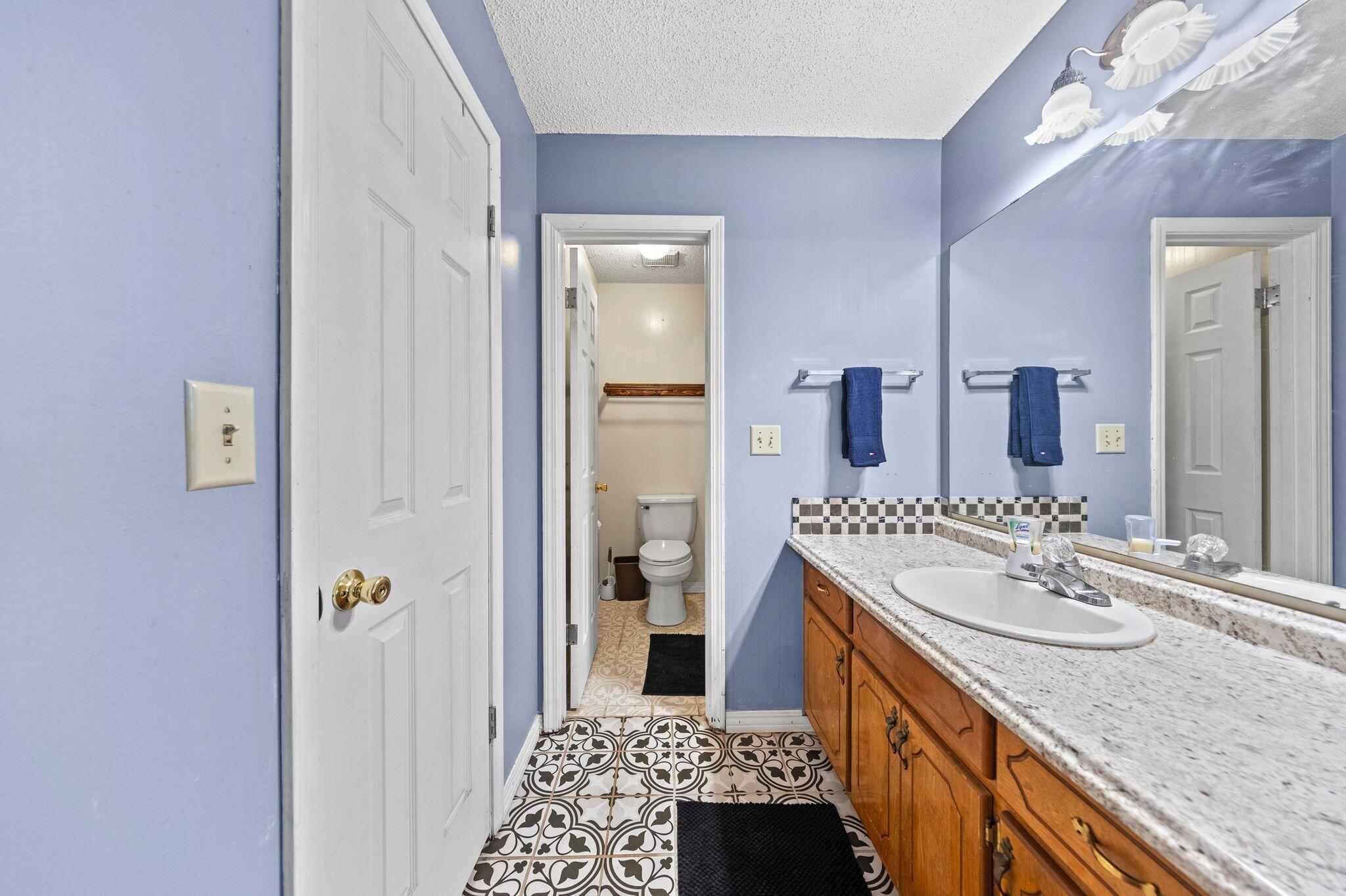 144 Oak Terrace Drive Crestview, FL 32539 - Photo 25 of 61 a en suite bathroom with a granite countertop sink and a mirror