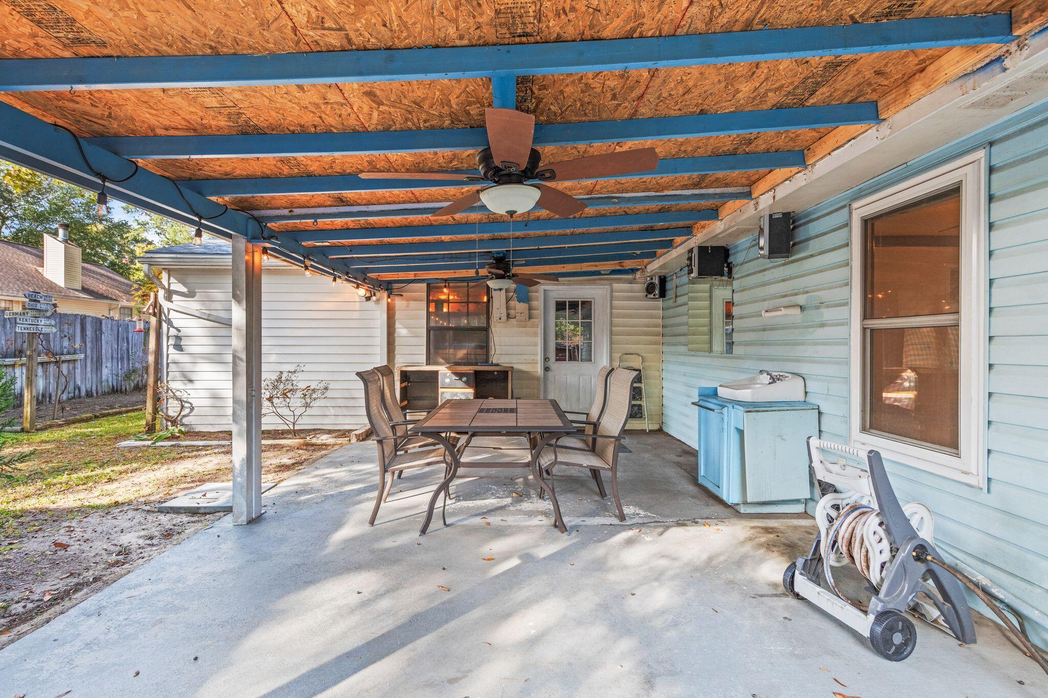 144 Oak Terrace Drive Crestview, FL 32539 - Photo 42 of 61 a patio with a table and chairs and potted plants