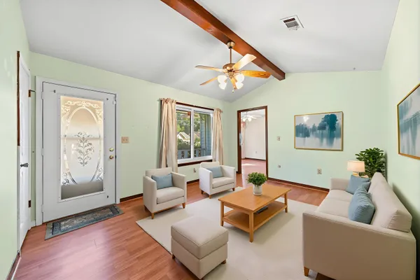 a living room with furniture and a wooden floor