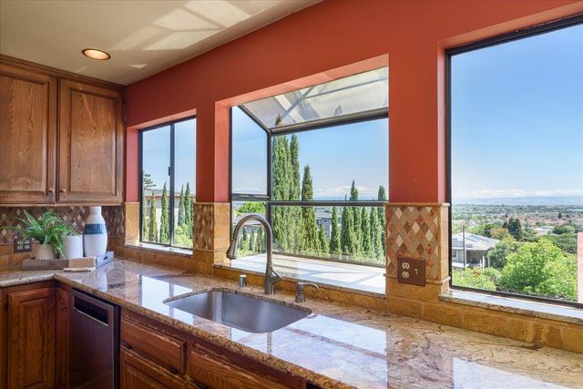 a kitchen with stainless steel appliances granite countertop a table chairs and a refrigerator