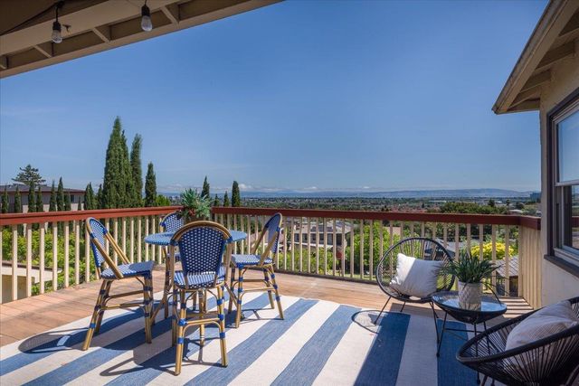 a patio with wooden table and chairs