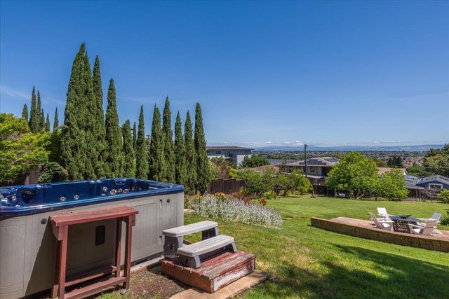 a view of a chair and table in backyard of the house