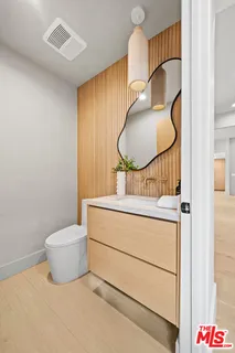 a bathroom with a toilet mirror and vanity