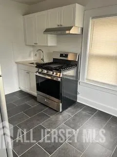 a stove top oven sitting inside of a kitchen