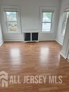 a view of a room with wooden floor and window