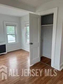 a view of a room with wooden floor and a window