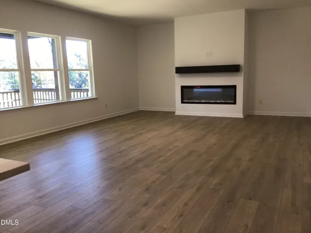 a kitchen with kitchen island a refrigerator and a wooden floor