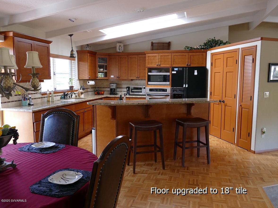 2275 Corral Road Sedona, AZ 86336 - Photo 13 of 30 a kitchen with stainless steel appliances kitchen island granite countertop a dining table chairs and a refrigerator