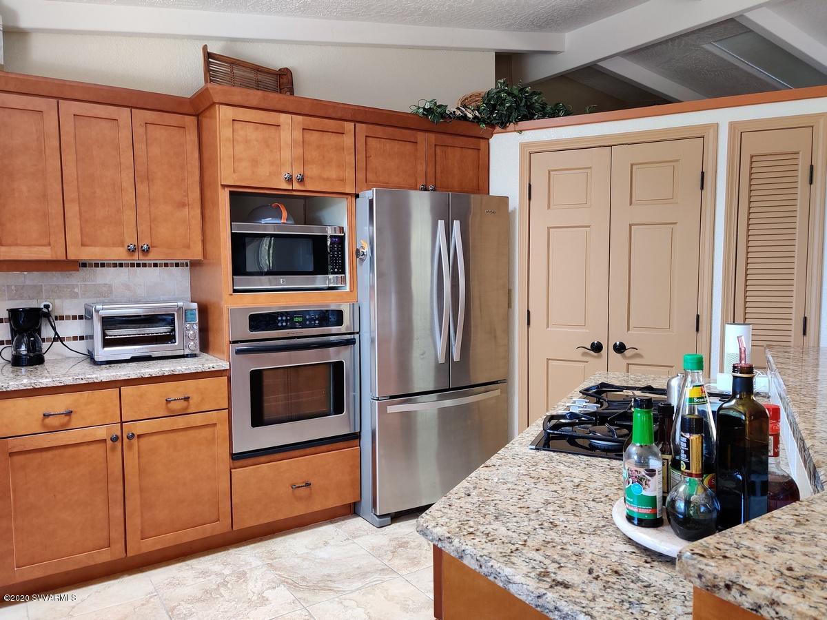 2275 Corral Road Sedona, AZ 86336 - Photo 15 of 30 a kitchen with stainless steel appliances kitchen island granite countertop a refrigerator and microwave
