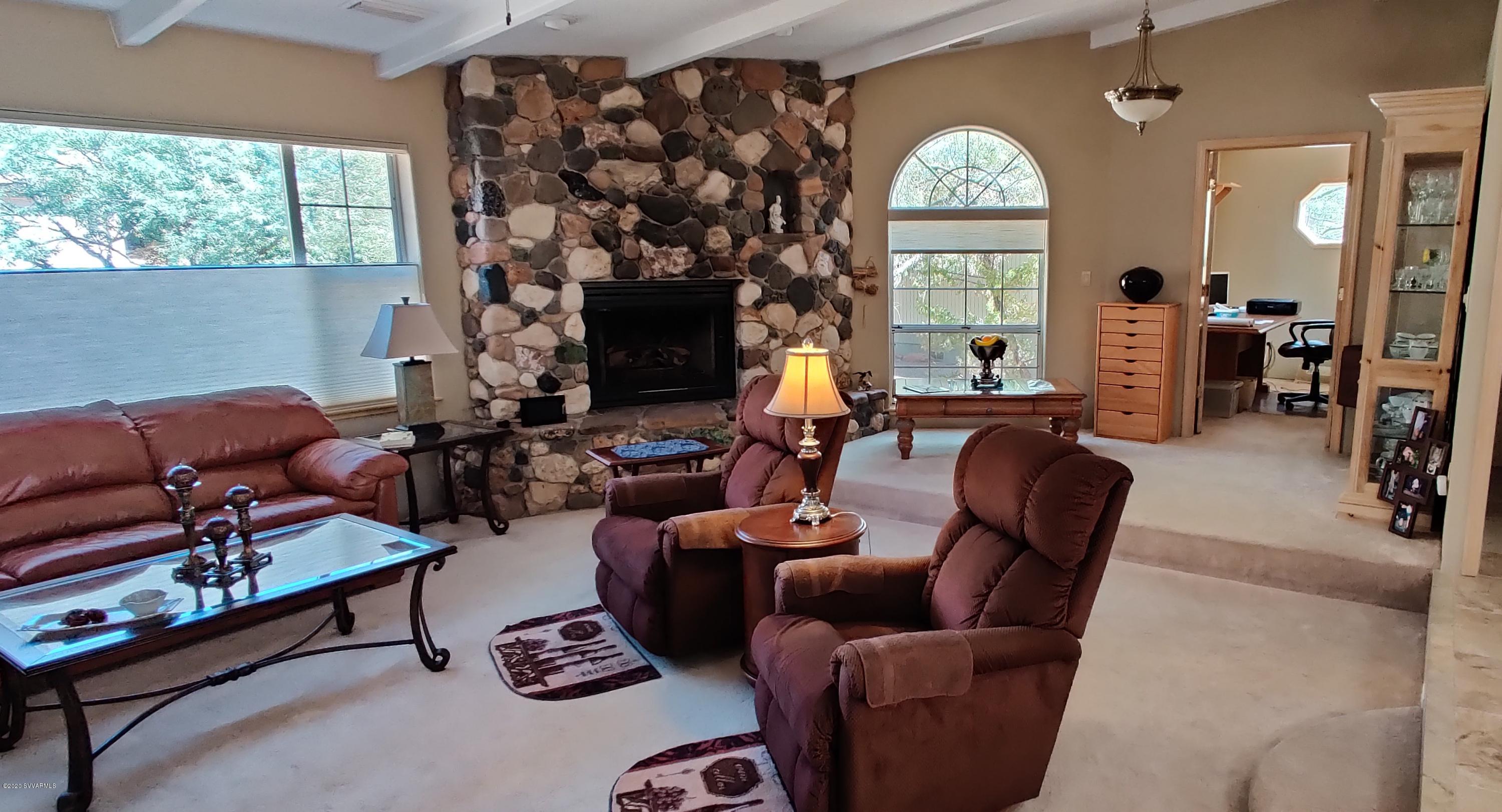 2275 Corral Road Sedona, AZ 86336 - Photo 18 of 30 a living room with furniture a large window and a fireplace
