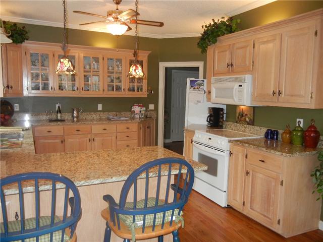 291 Laurel Crown Road Manchester, TN 37355 - Photo 8 of 20 a kitchen with stainless steel appliances granite countertop a stove a sink dishwasher and a dining table with cabinets