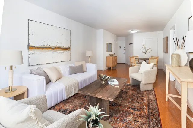 a living room with furniture a rug and a table