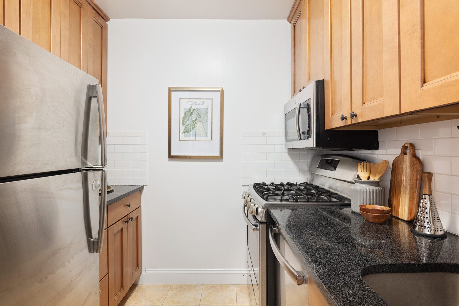 2025 Broadway, Unit 5C Manhattan, NY 10023 - Photo 3 of 10 a kitchen with stainless steel appliances granite countertop a refrigerator a stove and a sink with wooden floor