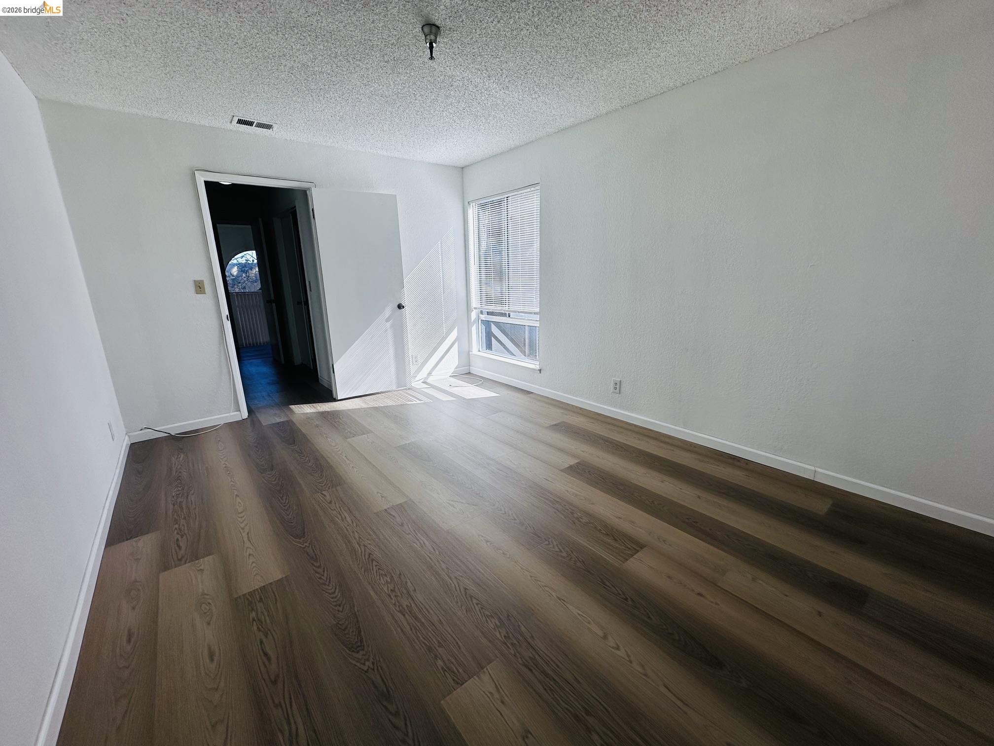 2121 Vale Road, Unit 50 San Pablo, CA 94806 - Photo 26 of 26 Wood-finish flooring with neutral wall paint and a large window