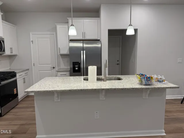a kitchen with kitchen island a sink stainless steel appliances and cabinets