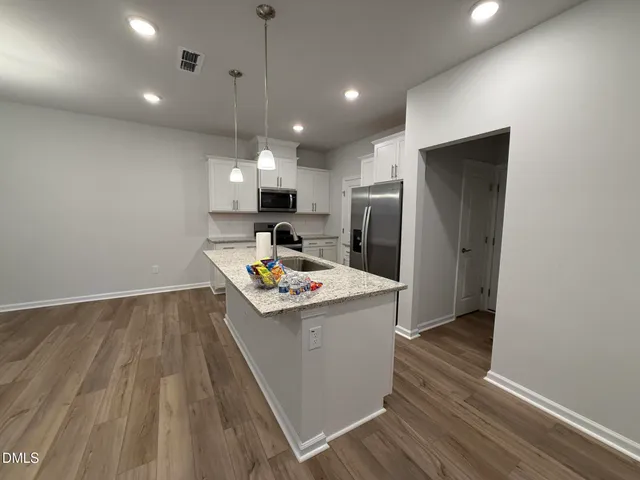 a kitchen with kitchen island white cabinets and stainless steel appliances