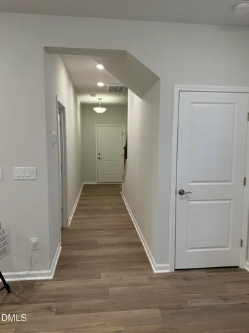 a view of a hallway with wooden floor