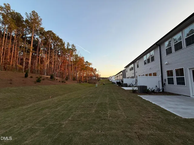 a view of a house with backyard and trees