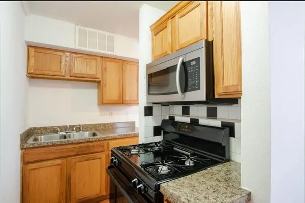 a kitchen with stainless steel appliances granite countertop a stove and a microwave