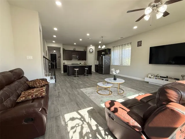 a living room with furniture and a flat screen tv with kitchen view