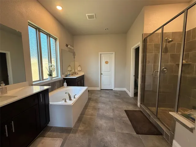 a bathroom with a tub a sink and a shower