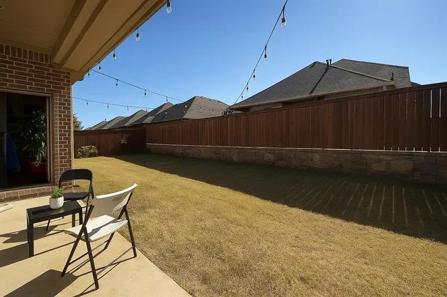 a backyard of a house with table and chairs