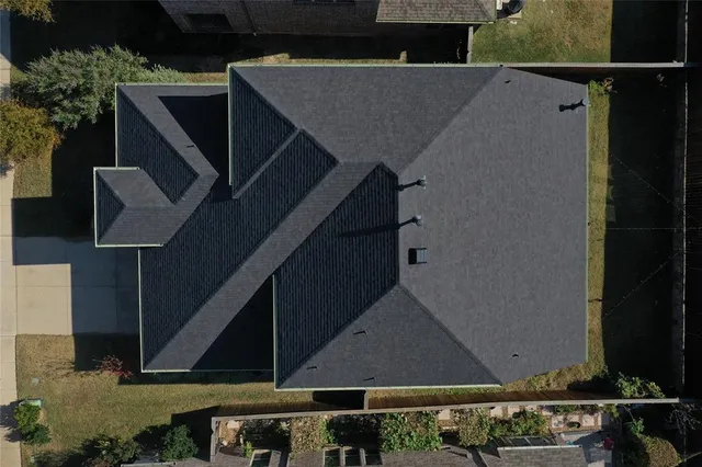 a roof deck with a table and chairs with wooden floor