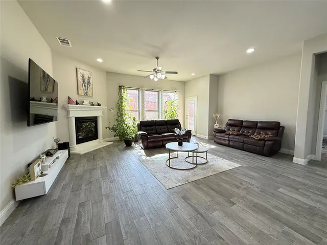 a living room with furniture a flat screen tv and a fireplace