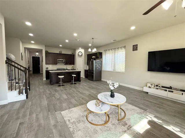 a living room with furniture a flat screen tv and kitchen view