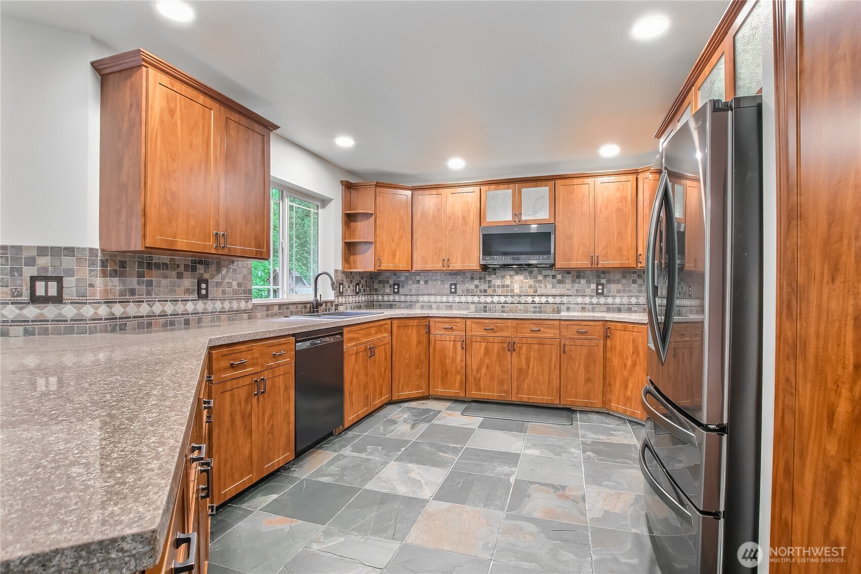 9430 Northeast 181st Lane Bothell, WA 98011 - Photo 5 of 25 a kitchen with stainless steel appliances granite countertop a sink counter space cabinets and a large window