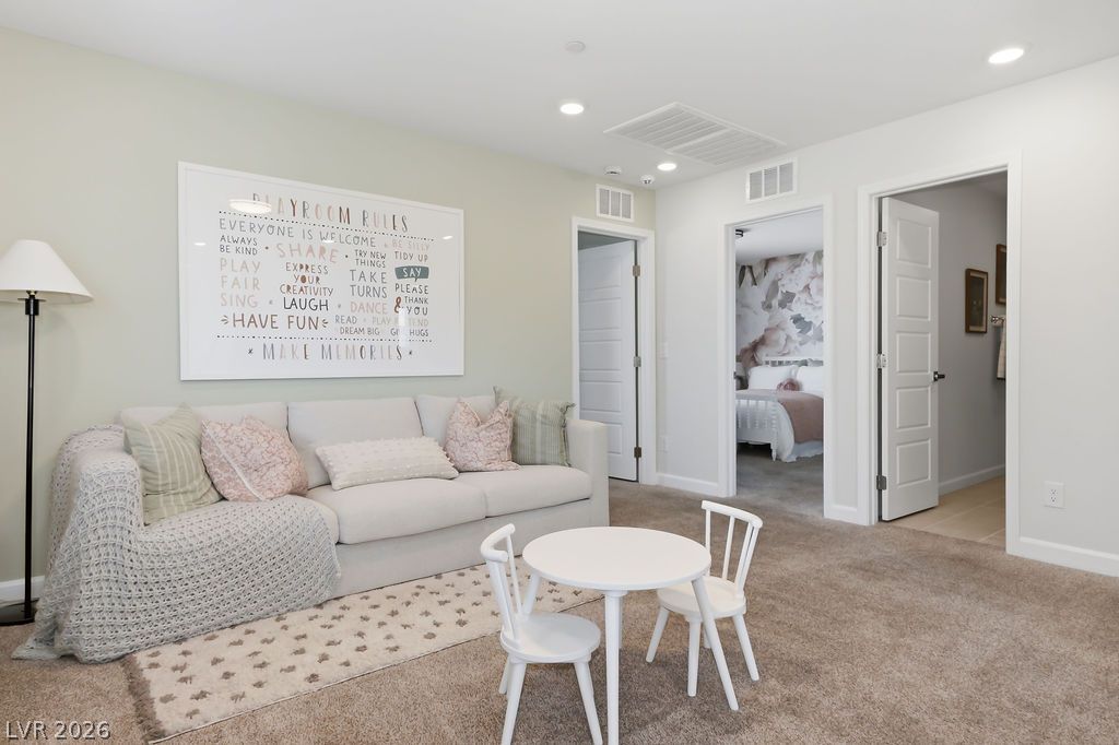 913 Cadence View Way Henderson, NV 89011 - Photo 26 of 46 A well-lit play space features plush carpeting and a comfortable sofa for relaxation.